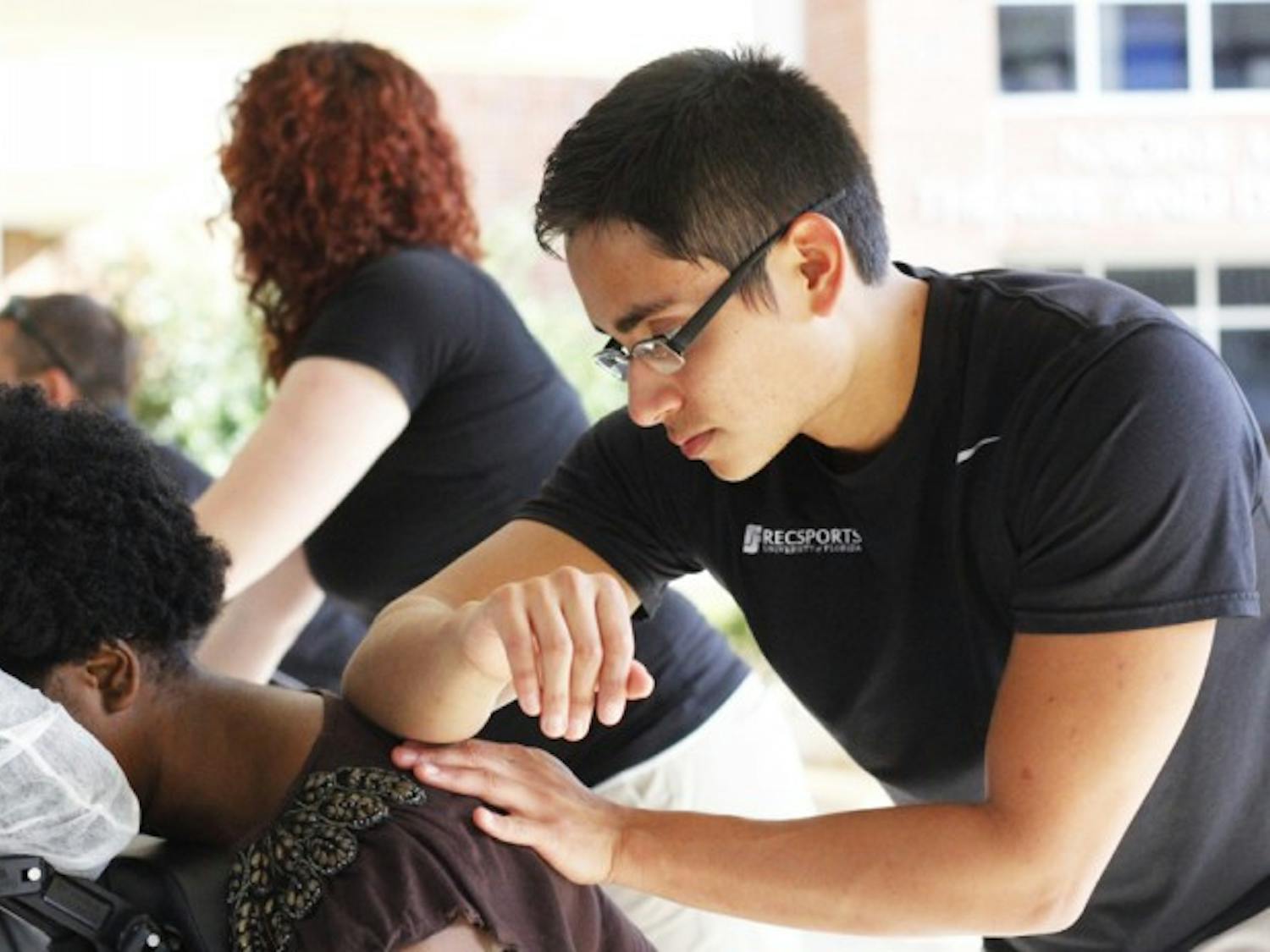 Andres Ramirez, a 23-year-old RecSports employee and food science and nutrition alumnus, massages Jennifer Polexi, a 18-year-old UF marketing sophomore. Polexi waited 15 minutes for her five-minute massage. “It felt like it wasn’t long at all,” she said.