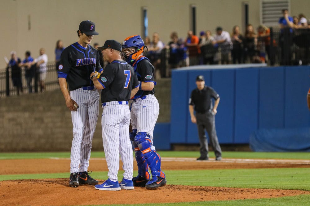 <p>UF pitcher Tommy Mace (left) speaking with coach Kevin O’Sullivan (middle) and catcher Brady Smith (right) during the UM series last year.</p>