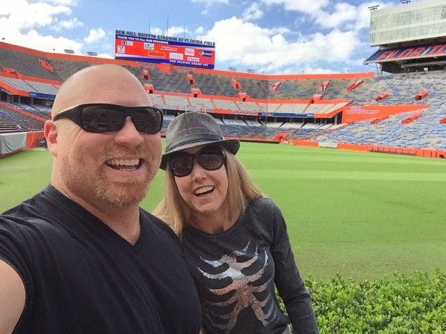 Chuck Ardezzone (left) and his wife Heather Champagne (right) take a picture at Ben Hill Griffin Stadium.