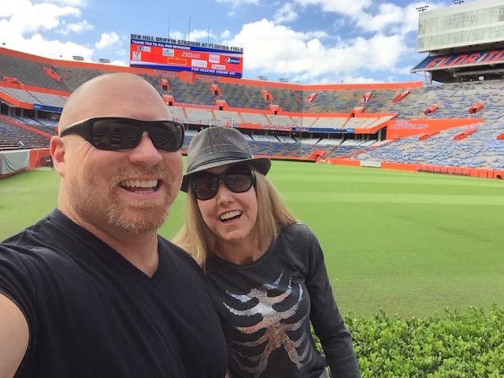 <p>Chuck Ardezzone (left) and his wife Heather Champagne (right) take a picture at Ben Hill Griffin Stadium.</p>