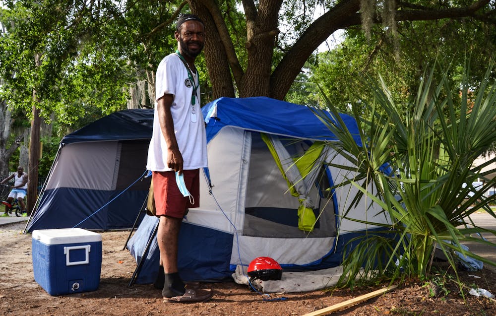 Robert Thomas, 43, stands in front of his tent behind the old fire station in downtown Gainesville where he says it’s “more peaceful” on Thursday, June 10, 2021. Thomas doesn’t know what he’ll do if the SPARC arts center is built, but says he’s willing to fight for the people camped out on the property. 