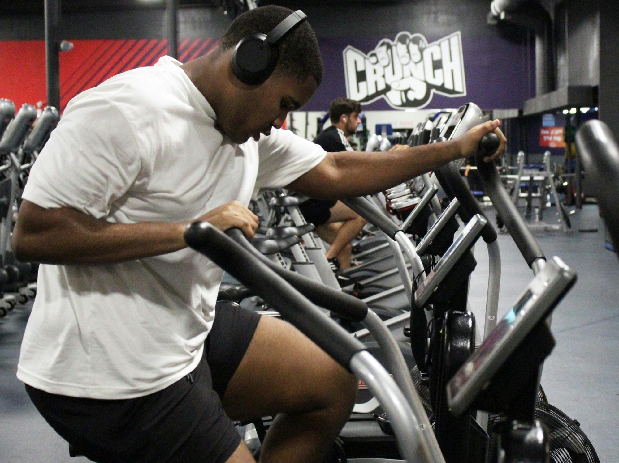 Jacob Geste pedals on a seated elliptical at Crunch Fitness on Tuesday, August 12, 2025.