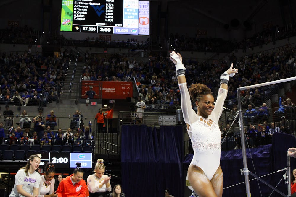 <p>Florida graduate student Trinity Thomas dismounts the bars at the end of her routine in a quad meet against the West Virginia Mountaineers, Ball State Cardinals and the Lindenwood Lions Friday, Jan. 6, 2023. </p>