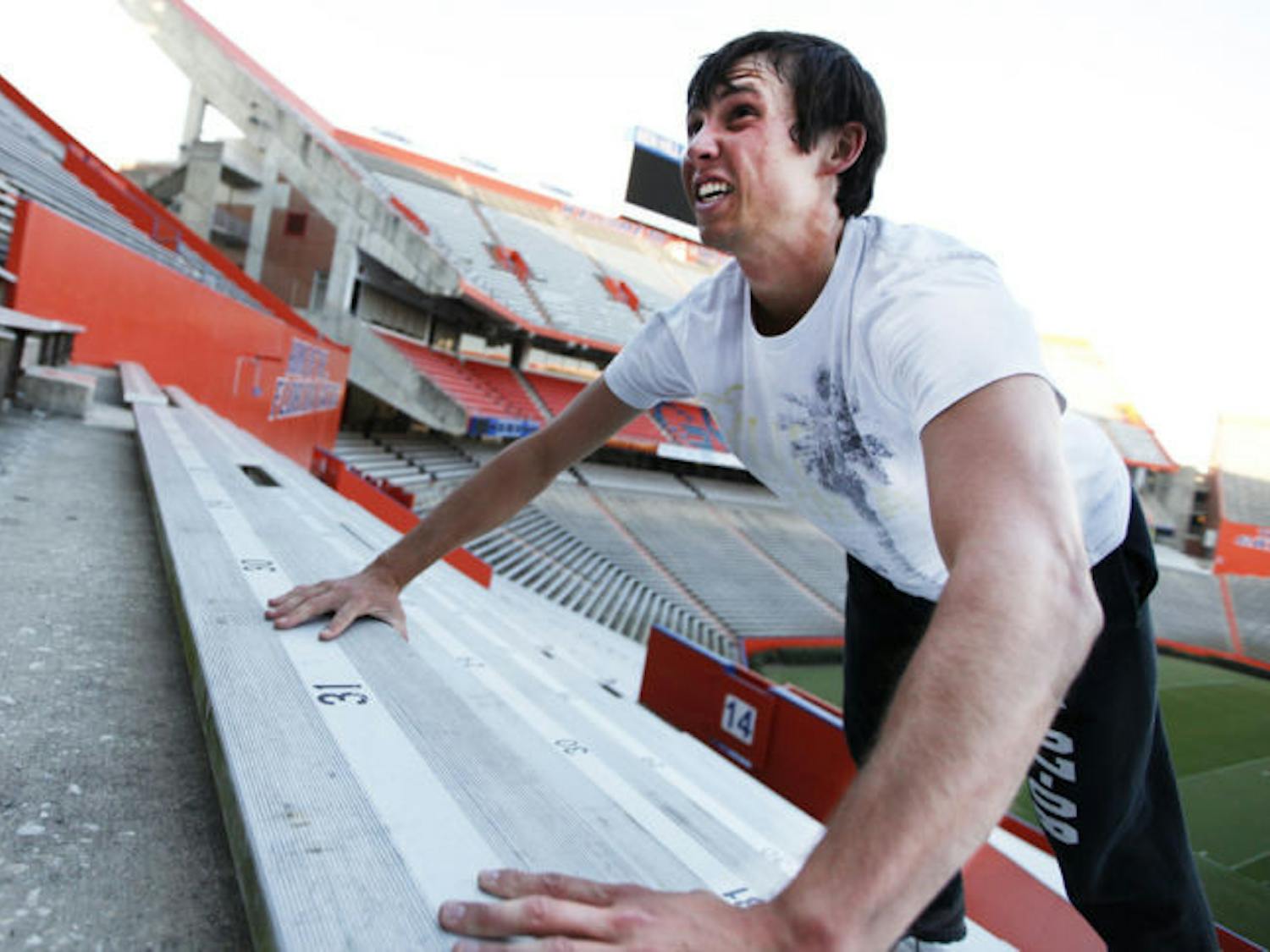 Conrad Cahoon, 22, a UF alumnus and intern with the Florida Springs Institute, exercises at Ben Hill Griffin Stadium on Tuesday evening.