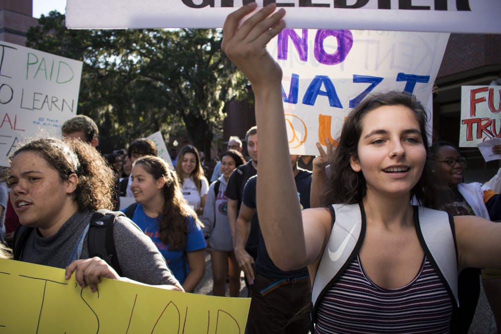 Jasmine Linares, a 21-year-old biology junior, marches alongside other protesters opposing Donald Trump Jr.'s speech Thursday night.
