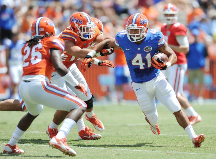 Hunter Joyer (41) attempts to avoid a tackle from Marcel Harris (26) and Quincy Williams (12) during the Orange &amp; Blue Debut on April 12 in Ben Hill Griffin Stadium. Joyer has the opportunity to play the B-position in Kurt Roper's spread offense.