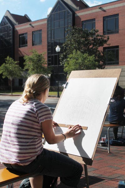 Janet Tauszik, a 19-year-old graphic design sophomore, draws Criser Hall as part of her perceptual drawing class Monday afternoon.