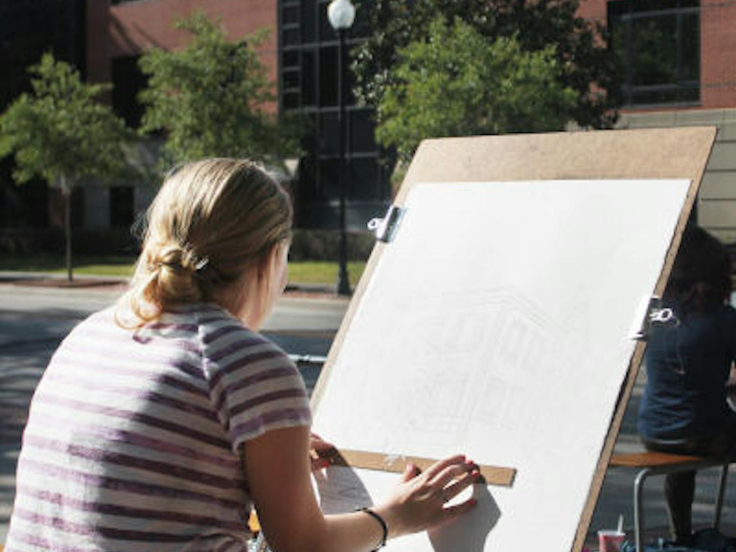 Janet Tauszik, a 19-year-old graphic design sophomore, draws Criser Hall as part of her perceptual drawing class Monday afternoon.