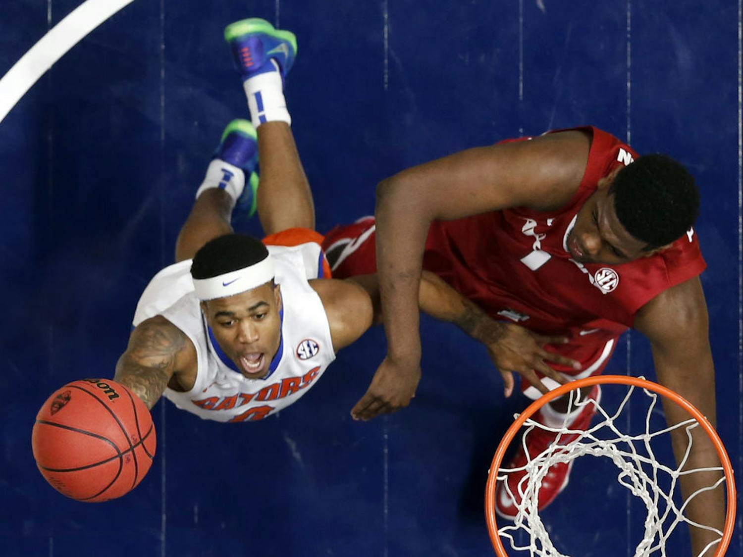 Florida's Kasey Hill, left, drives to the basket against Arkansas's Trey Thompson, right, during the first half of an NCAA college basketball game in the Southeastern Conference tournament in Nashville, Tenn., Thursday, March 10, 2016. (AP Photo/John Bazemore)Florida won 68-61.