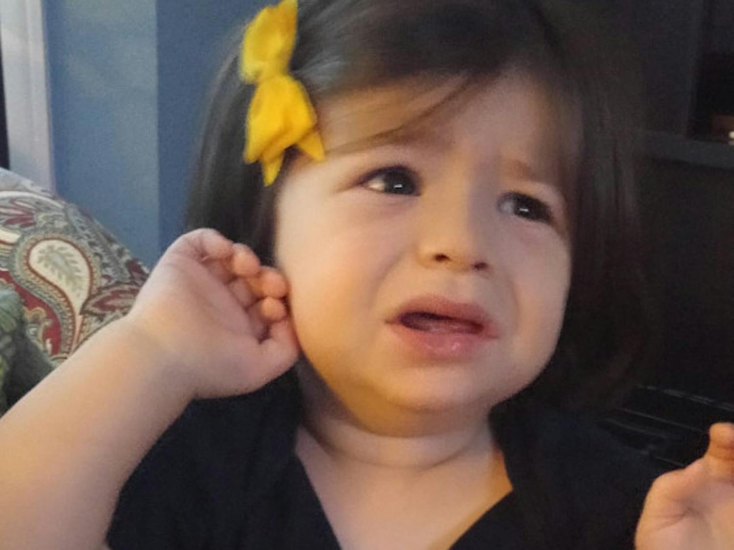 Lily, the daughter of tormented Gator fan Daniel Stone, offers an uncomfortable expression while wearing Michigan apparel.