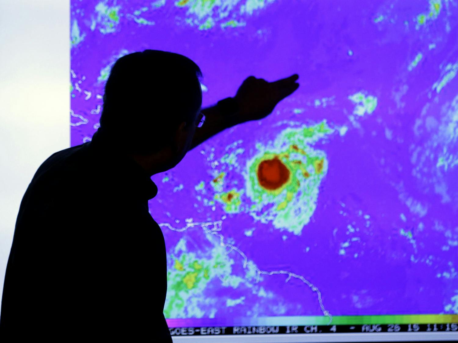 James Franklin, chief hurricane forecaster, looks at an image of Tropical Storm Erika as it moves westward towards islands in the eastern Caribbean, at the National Hurricane Center, Wednesday, Aug. 26, 2015, in Miami.