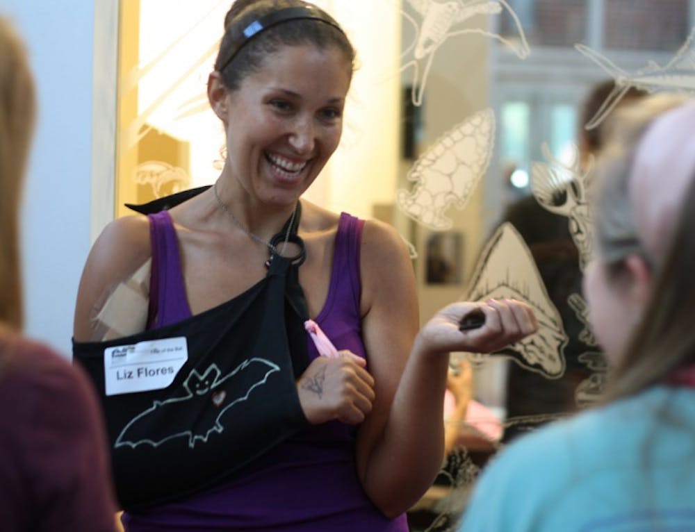 <p>Liz Flores, a 26-year-old volunteer at Tampa Bay Bats, feeds Uno the bat at the Year of the Bat Celebration at the Florida Museum of Natural History on Friday evening. Students and Gainesville residents gathered for an evening dedicated to bats that culminated in watching bats flying out of the Bat House on Museum Road.</p>