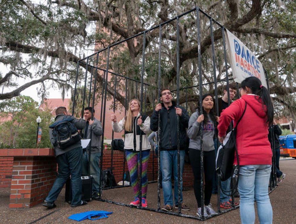 <p>Students from Dance Marathon set up a jail on Turlington Plaza on Wednesday afternoon. Members had a “bail” set, and pedestrians could pay for their release. In return, the dancers would perform. All proceeds were donated to Dance Marathon and Children’s Miracle Network.</p>