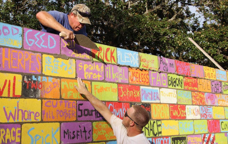Workers from Allan Spear Construction lay cement for the bricks in the Inter-Residence Hall Association’s “Writing on the Wall” project. The closing ceremonies will be on the Plaza of the Americas on Friday.