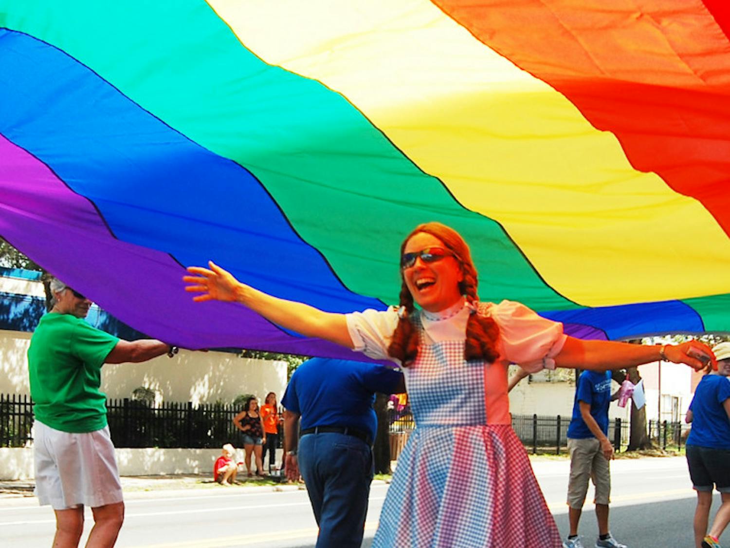 Julie Anspach, 56, dressed as Dorothy, rolls under a rainbow flag during the Gainesville Pride Festival and Parade on Saturday. The flag was held by church members of the United Church of Gainesville, who accept the LGBT community.