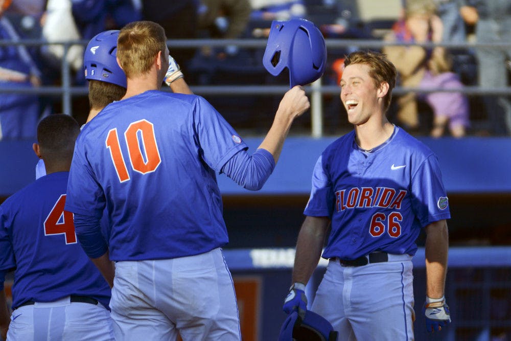 Ryan Larson celebrates with A.J. Puk (10) after hitting a home run during Florida's 22-3 win against Rhode Island on Saturday at McKethan Stadium.