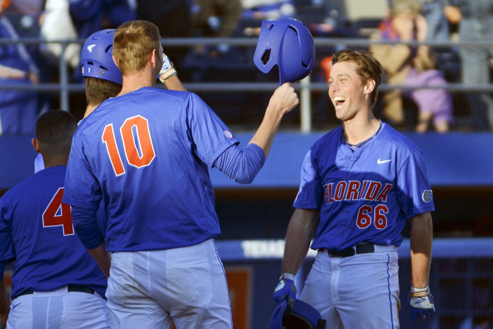 <p>Ryan Larson celebrates with A.J. Puk (10) after hitting a home run during Florida's 22-3 win against Rhode Island on Saturday at McKethan Stadium.</p>