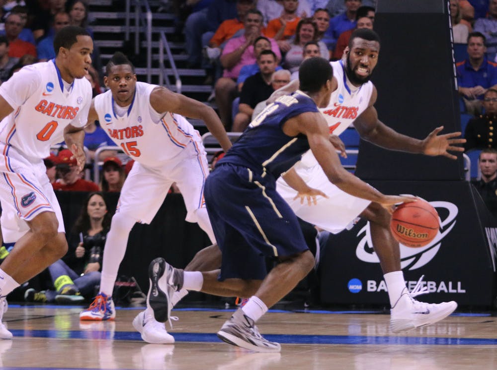 <p>Patric Young, who finished with a season-high four blocks, guards Pitt's Josh Newkirk during Florida's 61-45 victory on Saturday.</p>