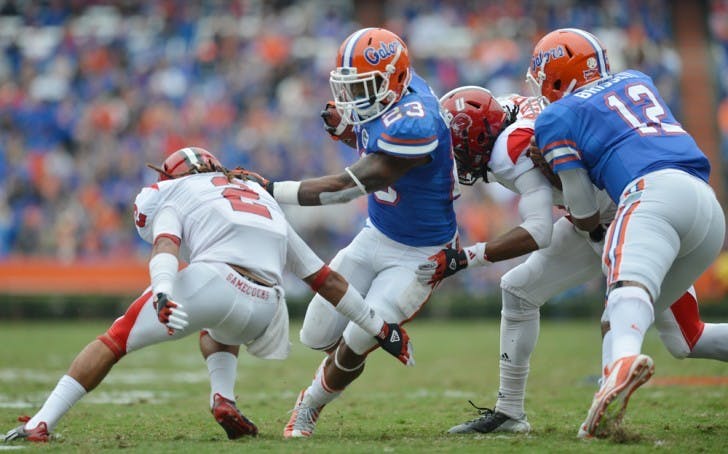 Running back Mike Gillislee (23) attempts to run through the Jacksonville State defense as quarterback Jacoby Brissett (12) blocks during UF’s 23-0 win on Saturday in The Swamp.

