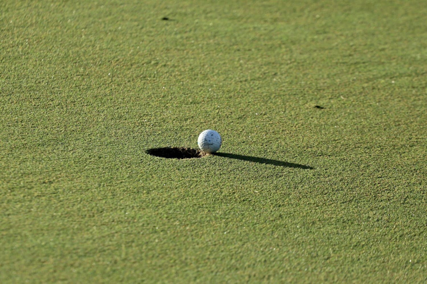 A ball hangs over the hole at Mark Bostick Golf Course