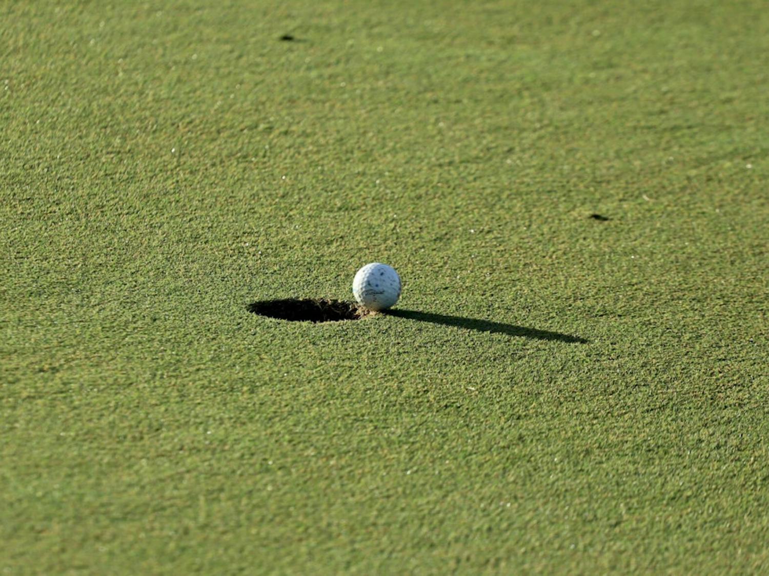 A ball hangs over the hole at Mark Bostick Golf Course