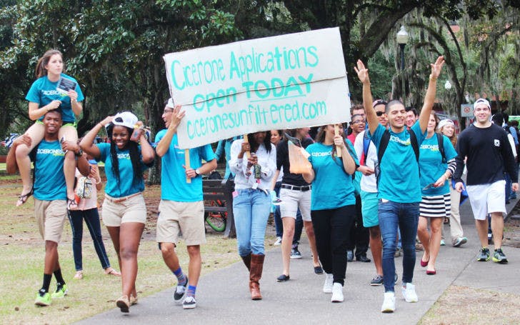 Members of the Florida Cicerones march in a parade to promote the opening of applications and the organization's Spring Forum on Jan. 14. The parade began in front of the HUB and ended on the Plaza of the Americas where representatives of the Gator Run threw orange and blue powder on the parade participants.