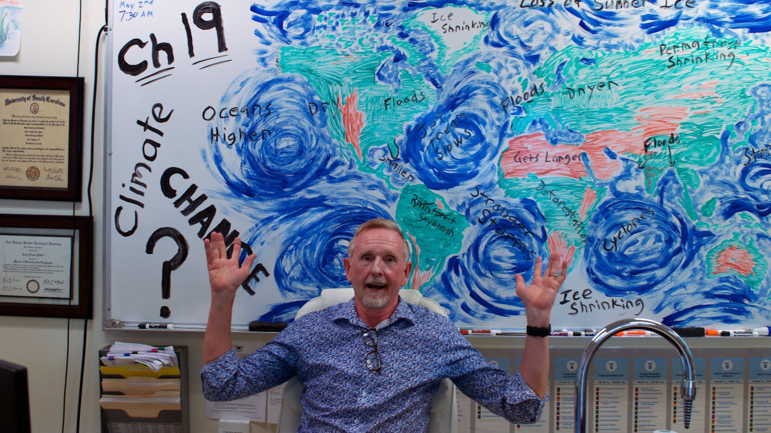 AP Environmental Science Teacher John Pettit sits in front of his illustration of climate change he made earlier in the day as an example for his students at Buchholz High School Tuesday, April 4, 2023. 