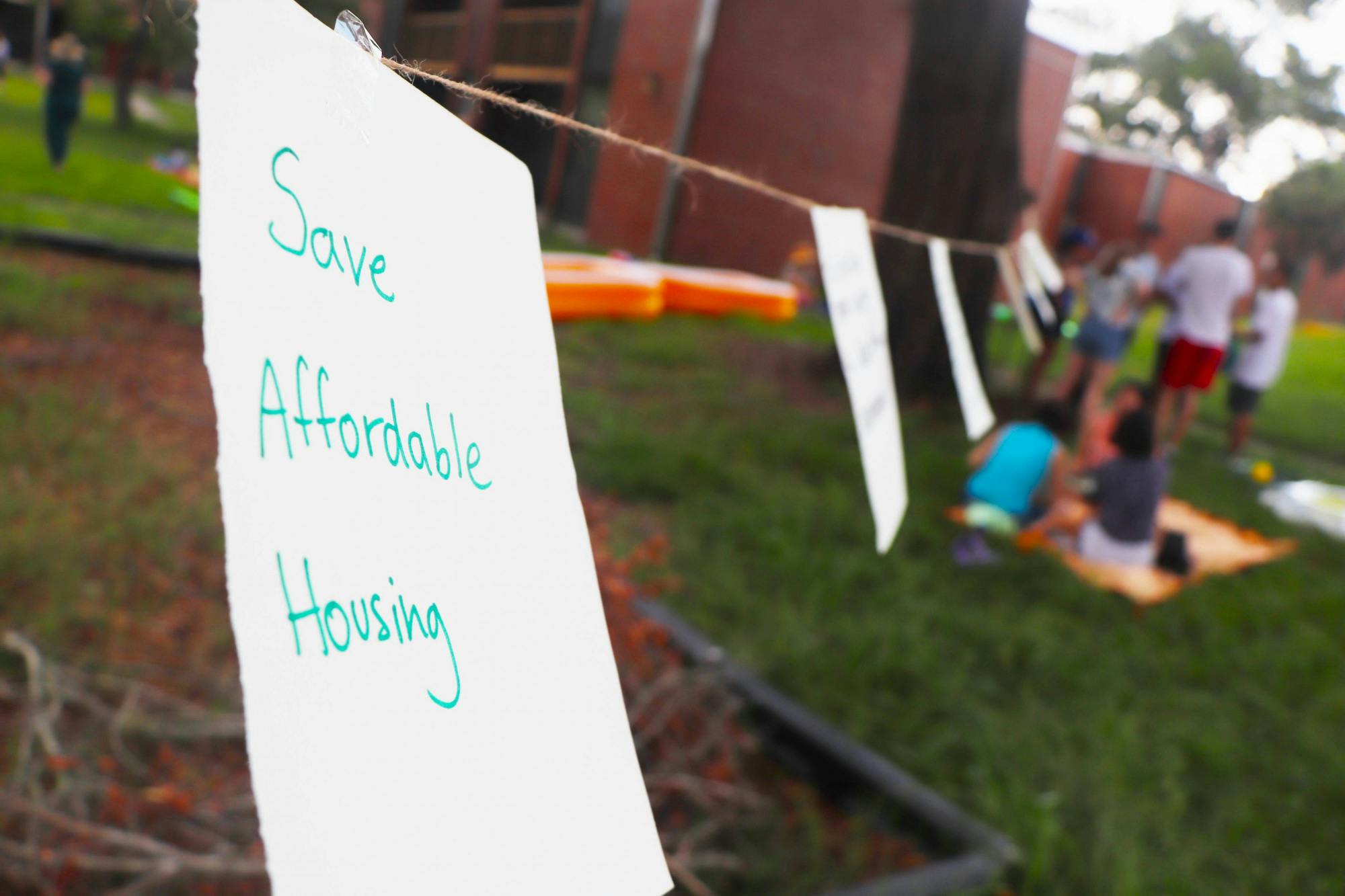 UF Graduate Assistants United and protestors share their sentiments about the state of graduate housing with written notes hung on a wire at Maguire Village on Saturday, June 10, 2023. 