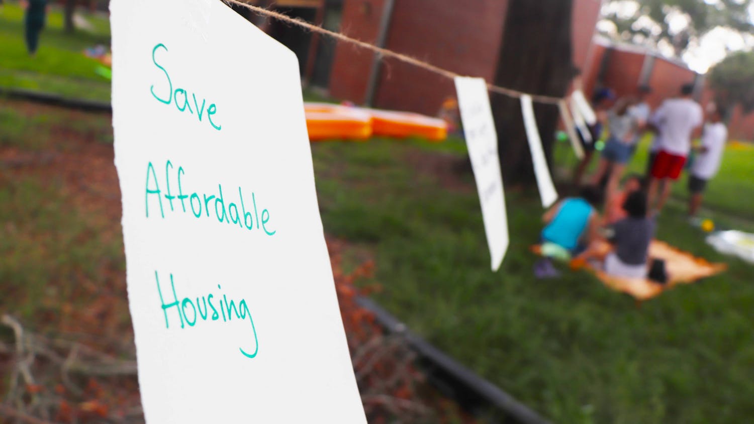 UF Graduate Assistants United and protestors share their sentiments about the state of graduate housing with written notes hung on a wire at Maguire Village on Saturday, June 10, 2023.