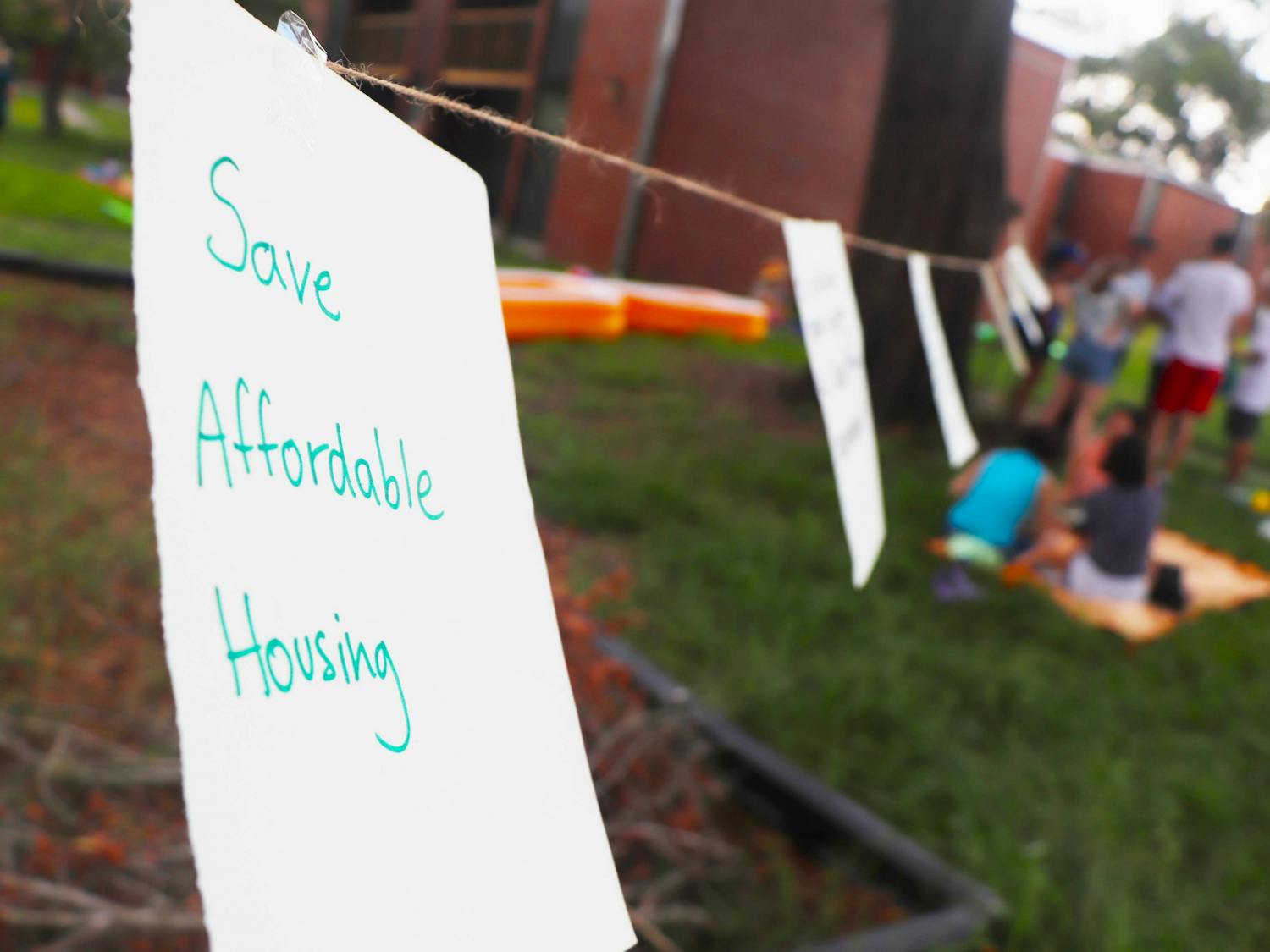 UF Graduate Assistants United and protestors share their sentiments about the state of graduate housing with written notes hung on a wire at Maguire Village on Saturday, June 10, 2023. 