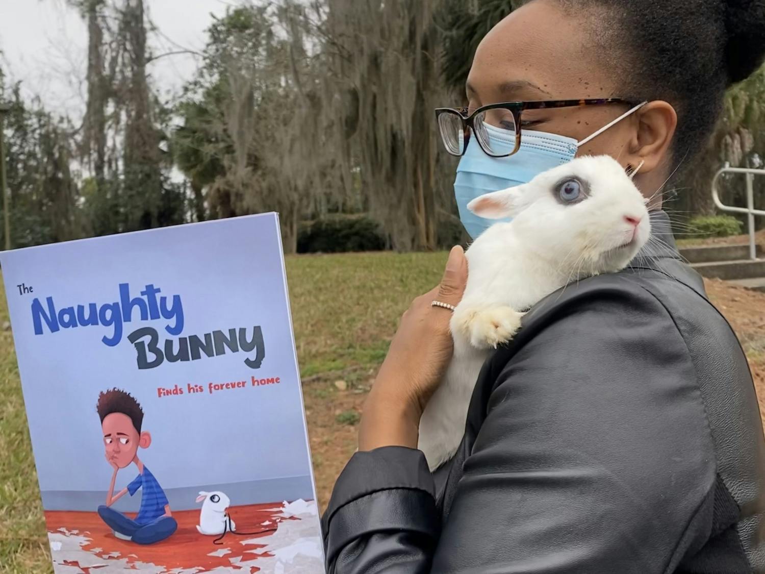 Rachel Evans holds pet rabbit Tiny and the book she co-authored with her son, Cameron Alvarado, about their journey with the pet.
