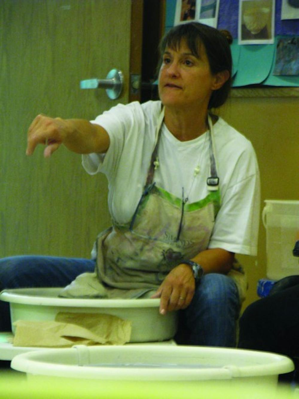 <p>Teresa Davis instructs her students during beginning throwing, a ceramics leisure course held in the J. Wayne Reitz Union&nbsp;Basement in the Arts &amp; Crafts Center.</p>