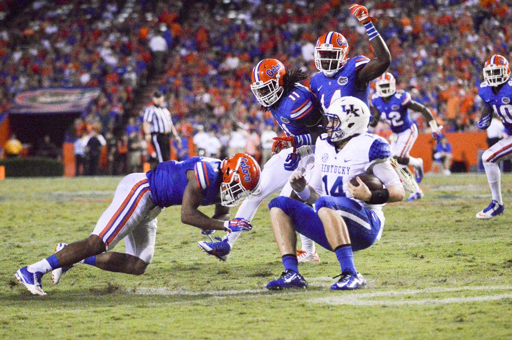 <p>Neiron Ball (11) helps tackle Kentucky Quarterback Patrick Towles (14) during the Gators' 36-30 win against the Wildcats on Satuday at Ben Hill Griffin Stadium.</p>