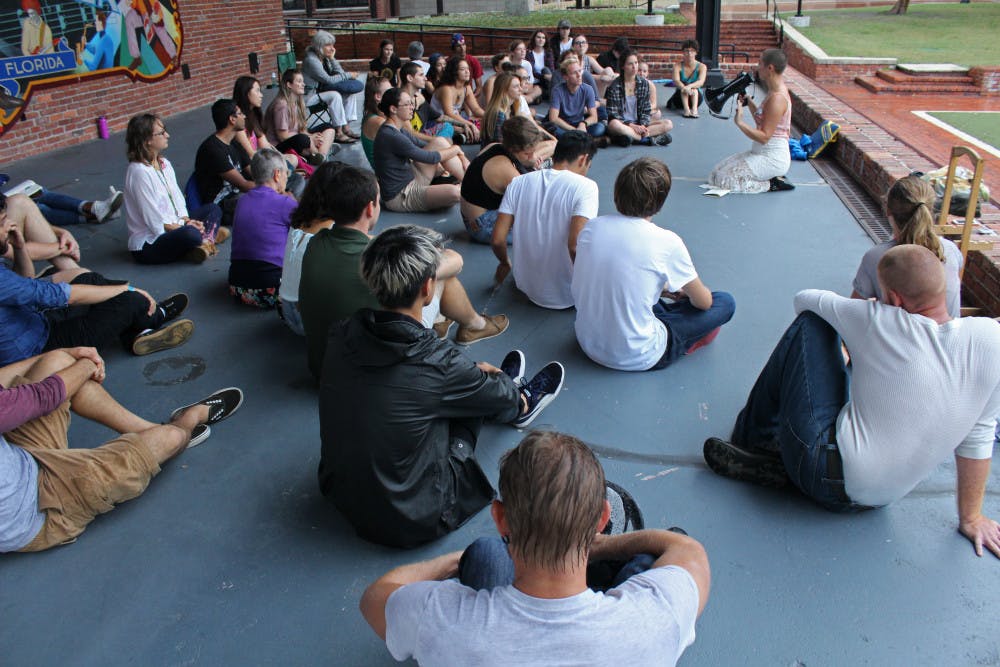 Marcela Mulholland, a 20-year-old UF political science and sustainability studies junior, speaks to the crowd with a megaphone at the World’s Biggest Eye Contact Experiment 2017. The event was centered around making eye contact with strangers for a full minute or longer.