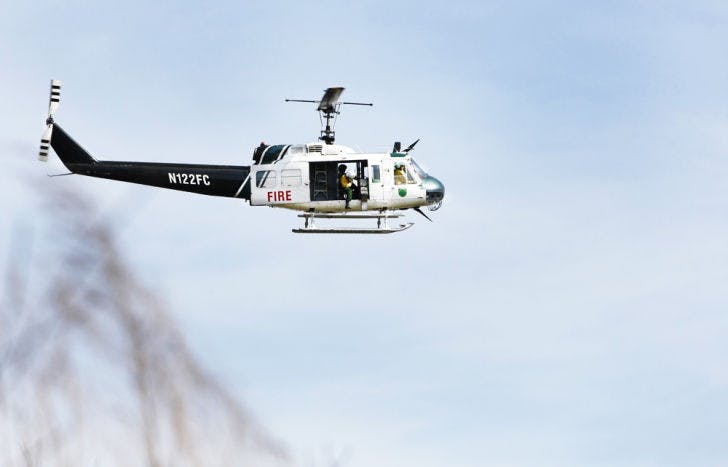 A Florida Forest Service helicopter drops small chemical-filled spheres that resemble ping pong balls over Paynes Prairie on Friday. The prescribed burn was aimed at ridding extra vegetation and combating the spread of hardwood trees.