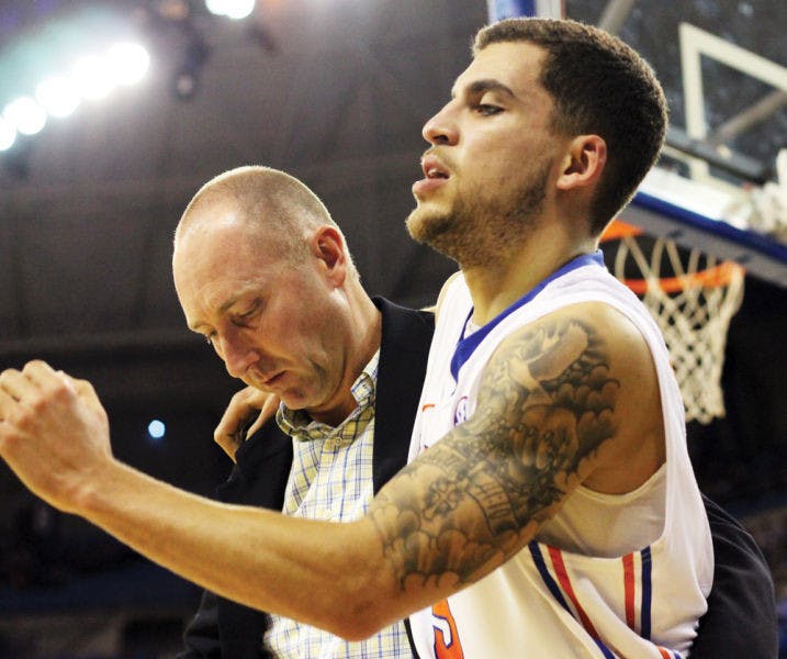 Scottie Wilbekin is helped off the court after rolling his right ankle during Florida’s 74-58 win against South Carolina on Wednesday in the O’Connell Center. This was the second right ankle injury Wilbekin has suffered this season.