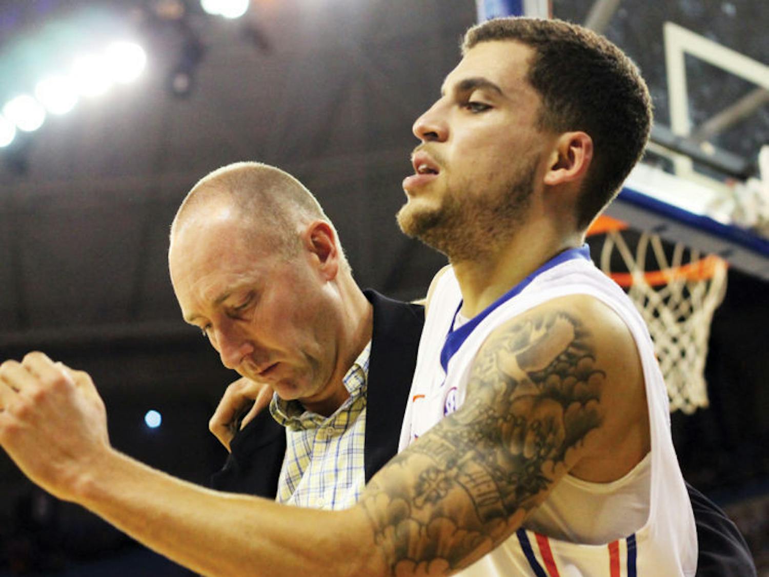 Scottie Wilbekin is helped off the court after rolling his right ankle during Florida’s 74-58 win against South Carolina on Wednesday in the O’Connell Center. This was the second right ankle injury Wilbekin has suffered this season.