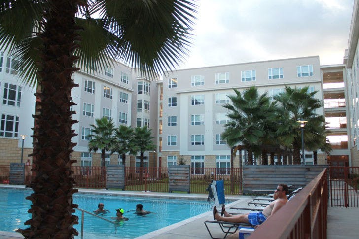Residents relax in the courtyard of The Continuum apartment complex Monday. A UF graduate and local attorney recently filed a complaint citing inconsistent leasing policies.
