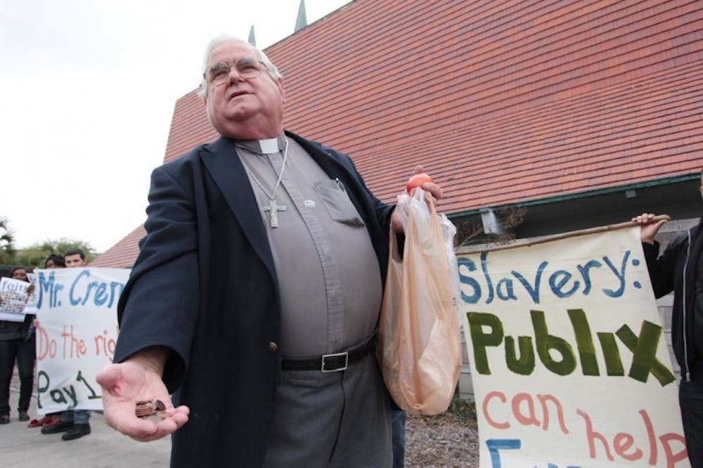 <p>Father Les Singleton hold out pennies to supporters of fair wages for Immokalee workers. According to Singleton, it would only cost Publix a penny per tomato to pay the Immokalee workers fair wages.</p>