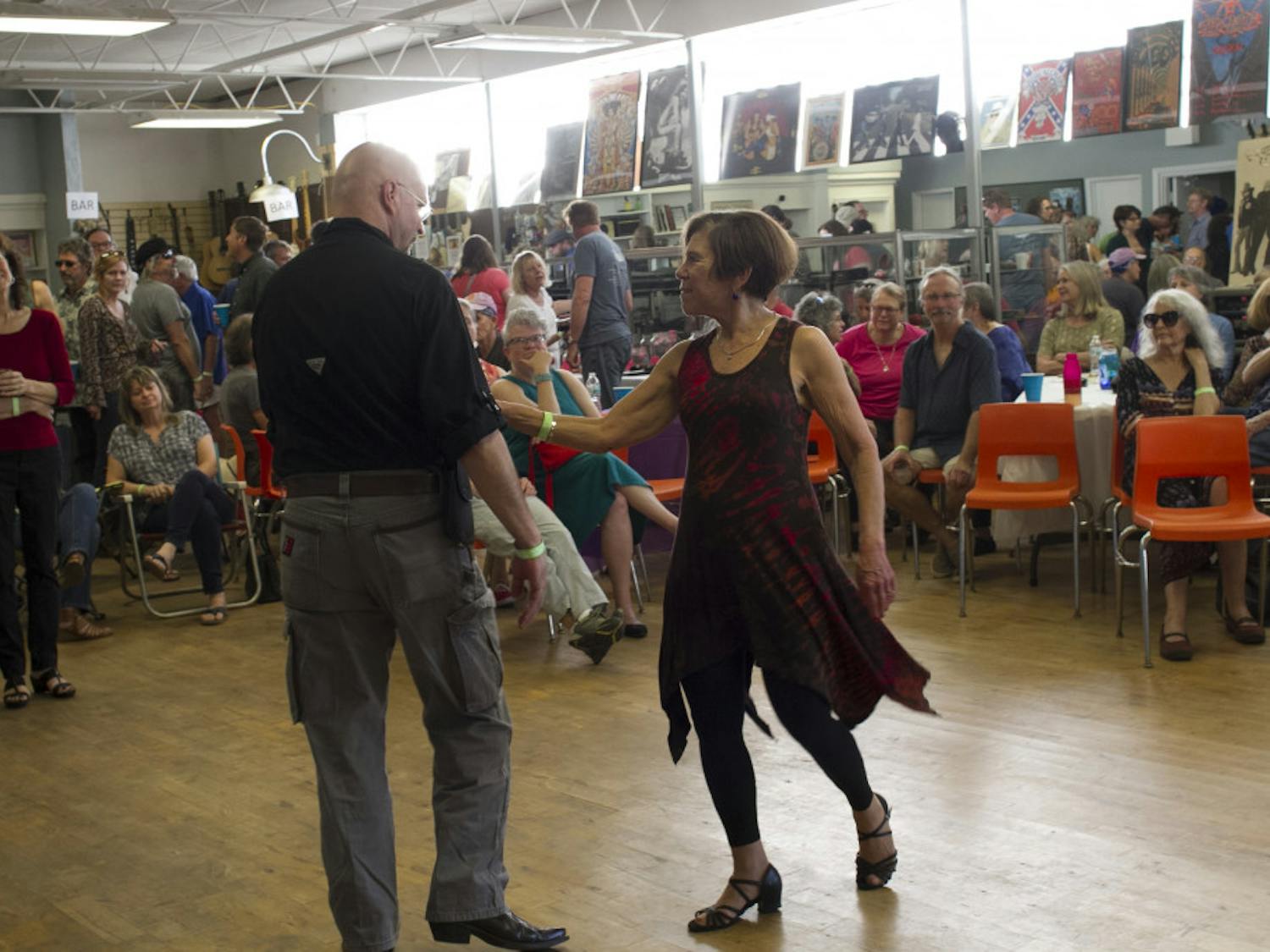Carol Perrine (far left) watches as two of her friends dance at the Carolpalooza benefit concert. 