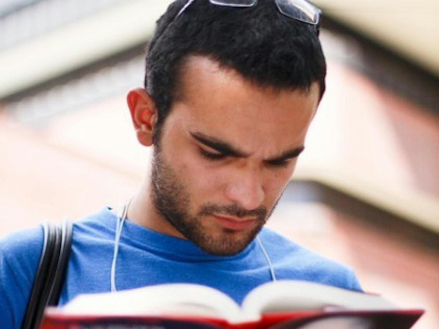 Chinese major senior Andrew Salcedo flips through the memoir of Chai Ling, the founder of All Girls Allowed on Turlington Plaza Friday.
