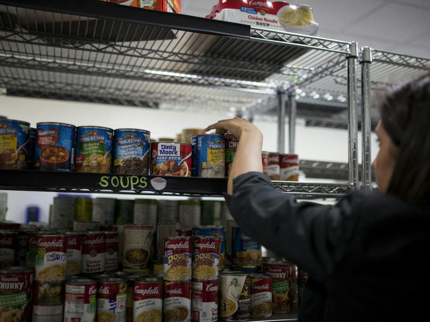 A volunteer stocking shelves with canned food at the Field and Fork Pantry on UF's campus in 2016. 