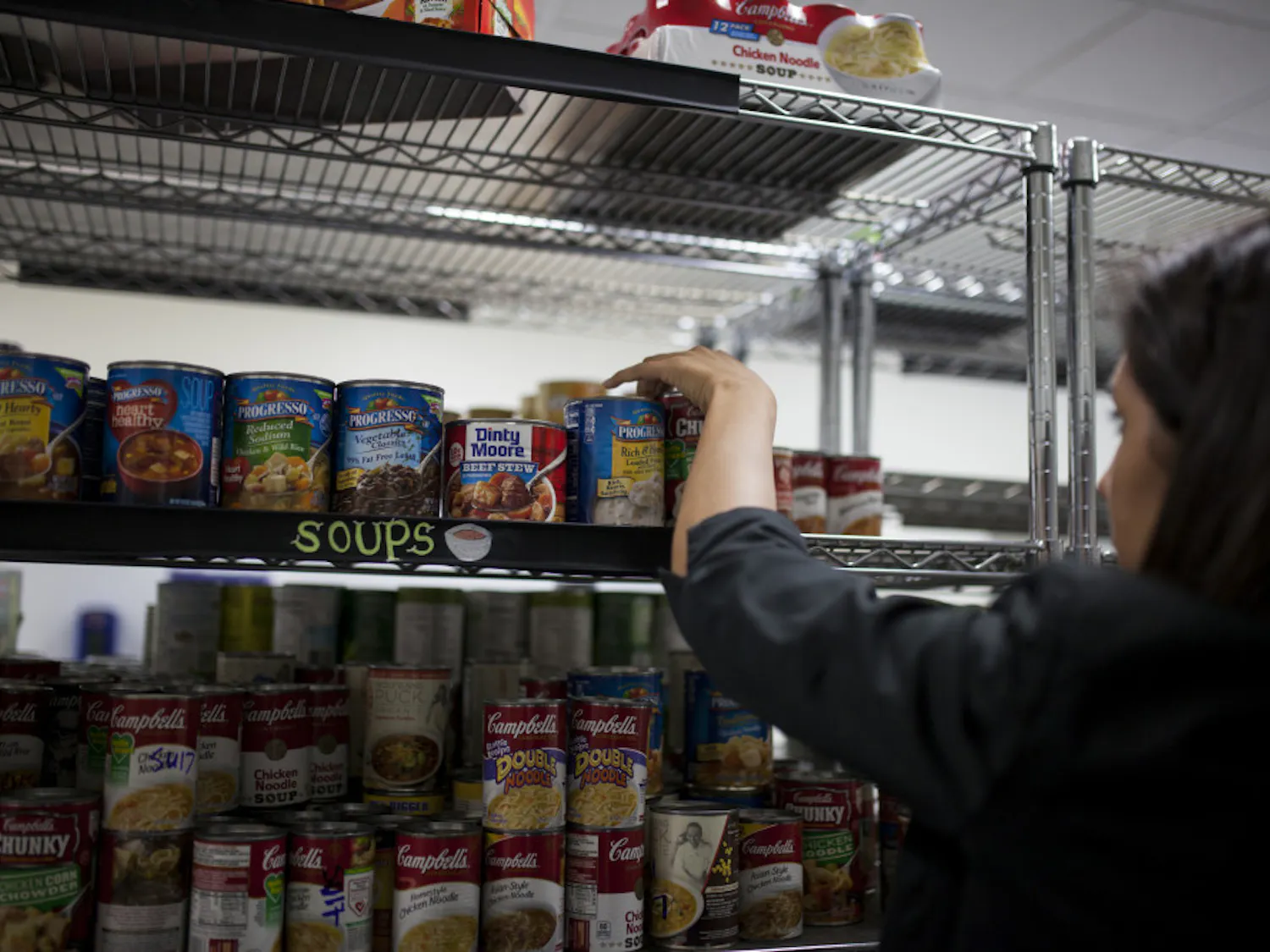 A volunteer stocking shelves with canned food at the Field and Fork Pantry on UF's campus in 2016.
