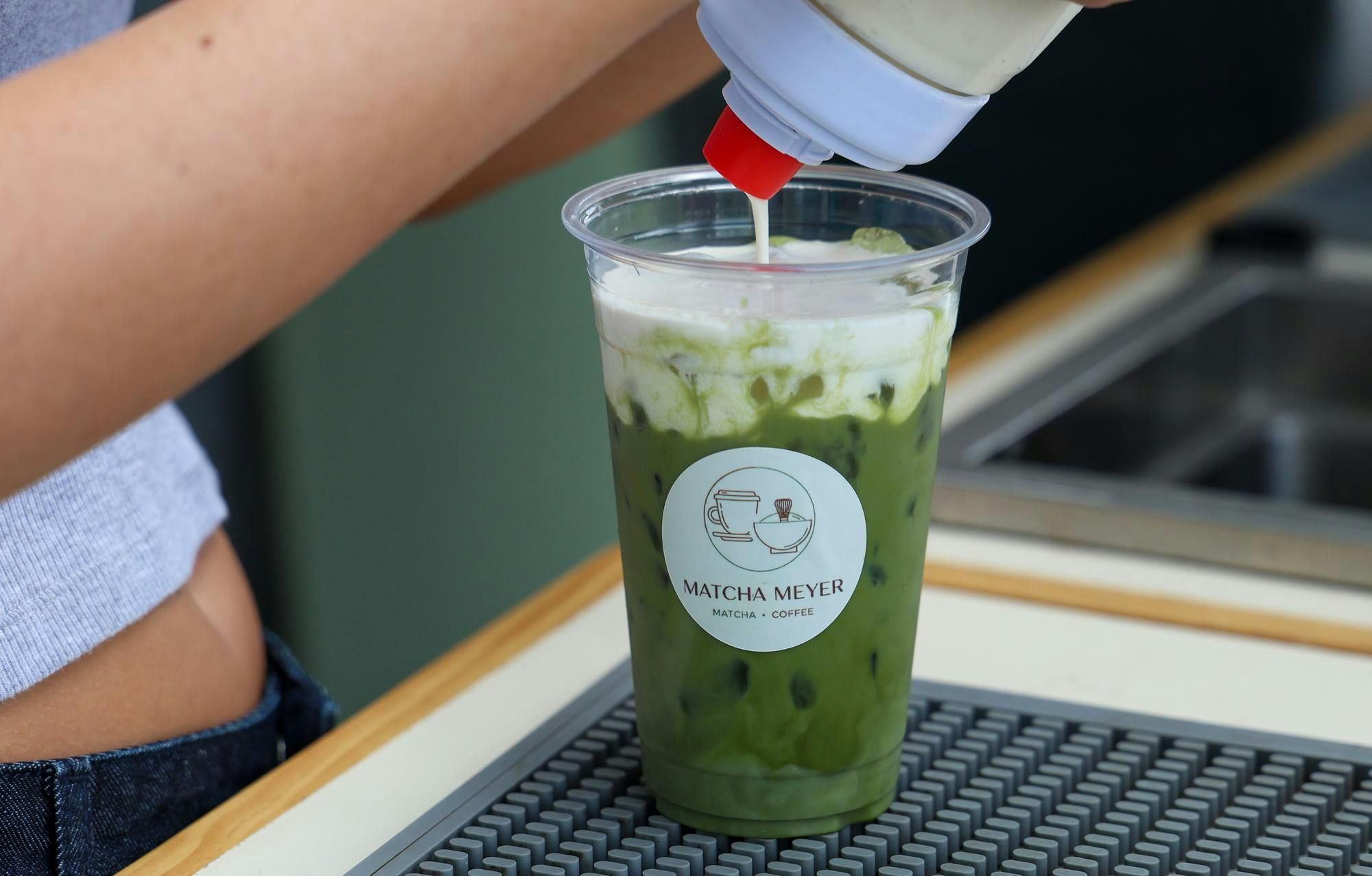 A Matcha Meyer volunteer pours vanilla cold foam into matcha at the 2026 Grill and Chill event at 931 Apartments on Friday, Sept. 11, 2026.