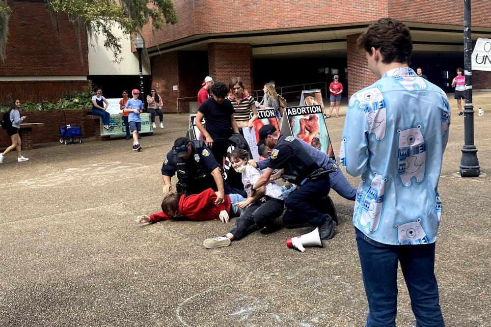 <p>Two UF students are arrested by University Police Department officers in Turlington Plaza Friday, March 10, 2023.</p>