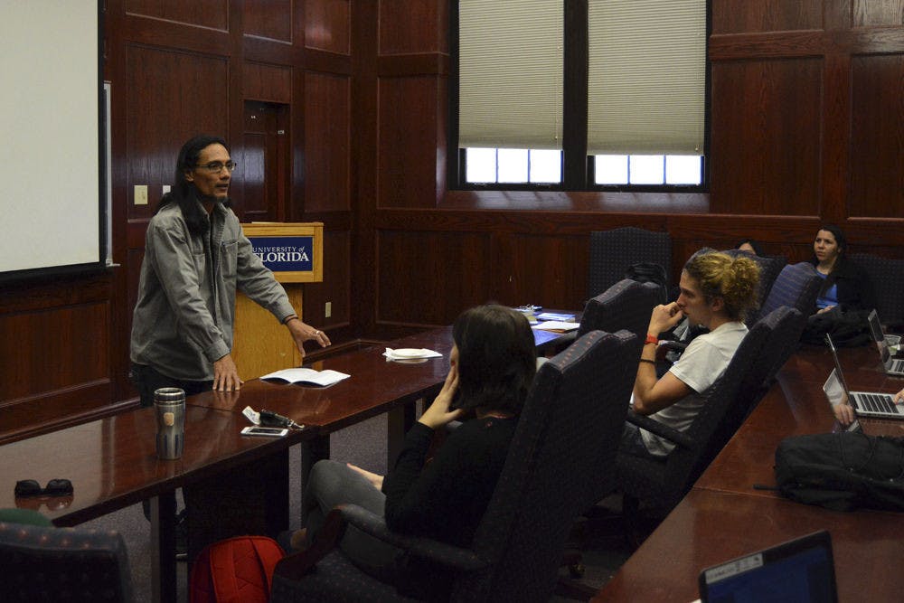 <p>Cuban science fiction author Michel Encinosa Fú, left, speaks an audience in Dauer Hall about gender in Cuban science fiction and fantasy on Wednesday during his first visit to the U.S. Eninosa Fú spoke to about 30 UF faculty and students about gender and sexual orientation in Cuban literature.</p>