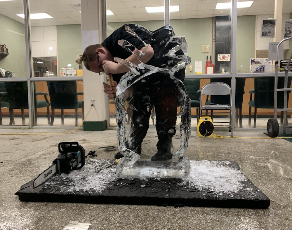 <p>Ian Vought uses an ice pick and a chainsaw to chisel a pineapple-shaped ice sculpture during the Career Academy Showcase at Eastside High School on Thursday, Nov. 18, 2021.</p>