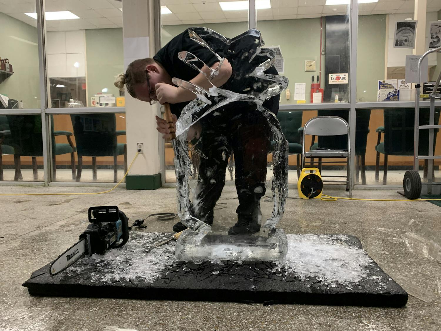 Ian Vought uses an ice pick and a chainsaw to chisel a pineapple-shaped ice sculpture during the Career Academy Showcase at Eastside High School on Thursday, Nov. 18, 2021.