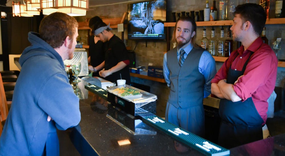 From left: Kyle McKenna, a 19-year-old UF psychology sophomore, chats with his older brother Sean McKenna, 25, and Michael Haas, 26, at Momoyaki. McKenna decided to visit Momoyaki’s Grand Opening before he starts working there.
