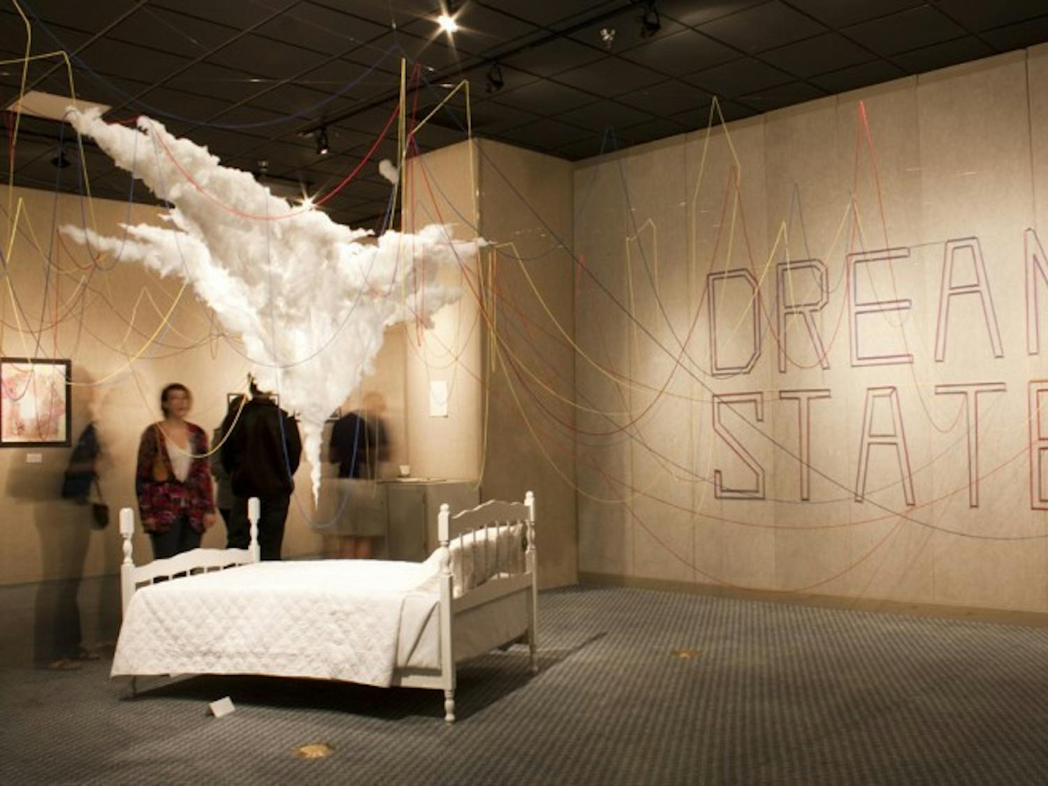 Visitors look at the exhibit "Dream State" at the grand opening show on Thursday evening in the Reitz Union Art Gallery.
